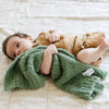 A little boy lays with a lighter green colored Bamboni® Saranoni Blanket. The soft blanket is a small blanket and a baby blanket as well as a mini blanket.