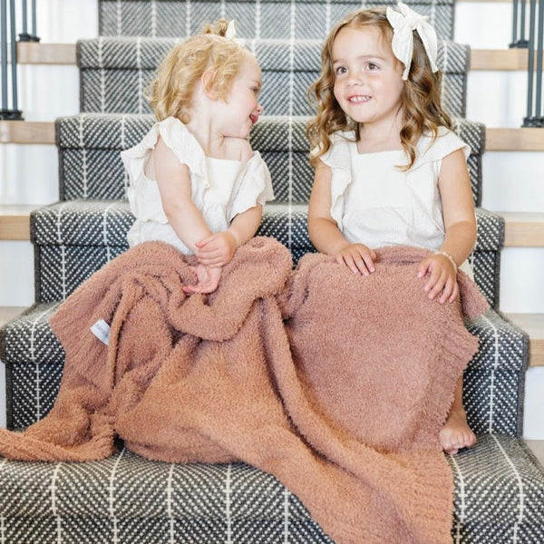 Two adorabel girls playing on stairs, sitting with stretchy, French Rose BAMBONI® TODDLER BLANKETS - Saranoni