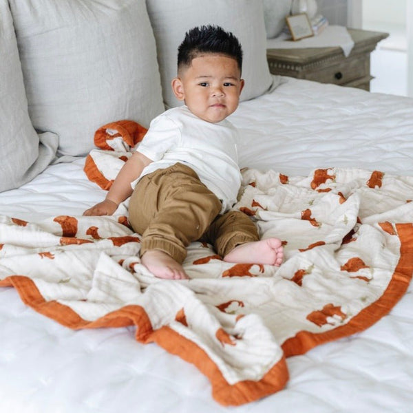 Little boy laying with a soft and breathable bamboo rayon muslin quilt with a stunning pattern, perfect for year-round comfort and style.