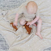 Little boy playing on a star patterned bamboo rayon muslin quilt. 