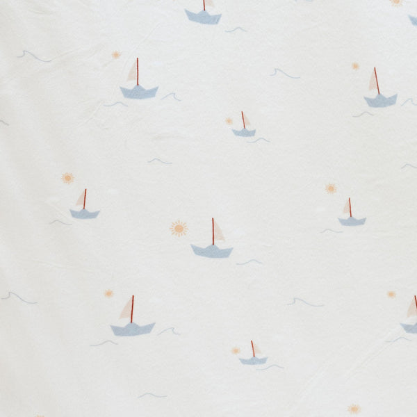 Close-up of Minky Stretch Luxe fabric in a delicate sail boat pattern. Made from 94% polyester and 6% spandex, this ultra-soft, stretchy fabric is perfect for baby essentials like swaddles, changing pad covers, and crib sheets.