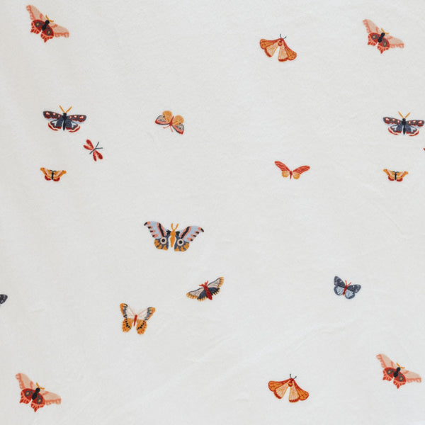 Close-up of Minky Stretch Luxe fabric in a delicate butterfly pattern, featuring multiple kind of butterflies. Made from 94% polyester and 6% spandex, this ultra-soft, stretchy fabric is perfect for baby essentials like swaddles, changing pad covers, and crib sheets.