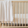 A Minky Stretch Luxe swaddle in a gingham pattern, featuring ultra-soft minky fabric with a luxurious stretch, perfect for keeping your baby cozy and comfortable. Ideal for newborns and infants is on a crib where the Minky Stretch Luxe crib sheet in a gingham pattern, designed with soft and stretchy minky fabric for ultimate comfort. Perfect fit for standard crib mattresses, offering a cozy and luxurious sleep environment for your baby.