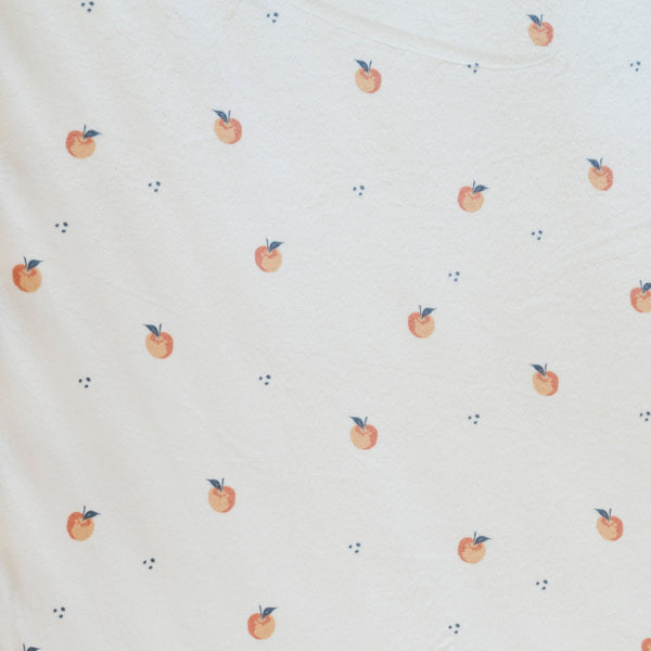 Close-up of Minky Stretch Luxe fabric in a delicate apple pattern. Made from 94% polyester and 6% spandex, this ultra-soft, stretchy fabric is perfect for baby essentials like swaddles, changing pad covers, and crib sheets.