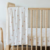 A Minky Stretch Luxe swaddle in a apple pattern, featuring ultra-soft minky fabric with a luxurious stretch, perfect for keeping your baby cozy and comfortable. Ideal for newborns and infants is on a crib where the Minky Stretch Luxe crib sheet in a apple pattern, designed with soft and stretchy minky fabric for ultimate comfort. Perfect fit for standard crib mattresses, offering a cozy and luxurious sleep environment for your baby.