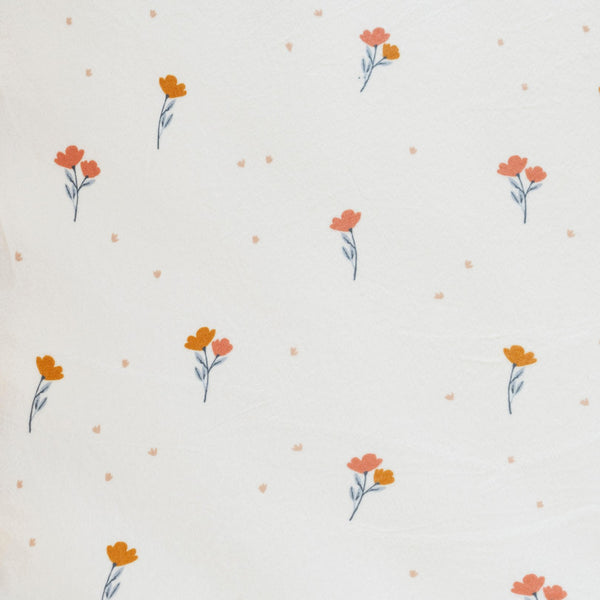 Close-up of Minky Stretch Luxe fabric in a delicate floral pattern. Made from 94% polyester and 6% spandex, this ultra-soft, stretchy fabric is perfect for baby essentials like swaddles, changing pad covers, and crib sheets.