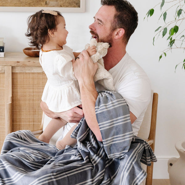 Dad and daughter playing with blue and white striped MINKY STRETCH RECEIVING BLANKETS - Saranoni