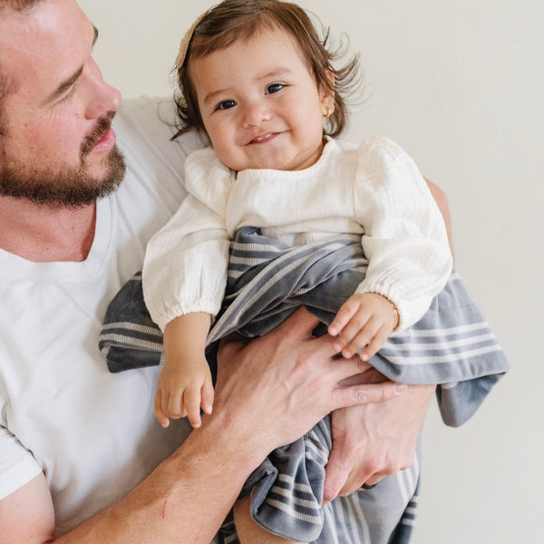 Baby smiling with striped MINKY STRETCH RECEIVING BLANKETS - Saranoni