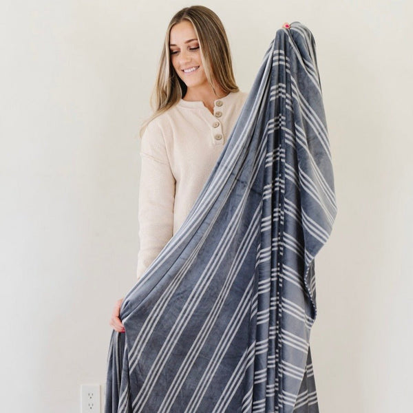 Girl holding out striped MINKY STRETCH XL THROW BLANKETS - Saranoni