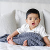 Little boy on bed with super soft and stretchy Charcoal RIBBED BAMBONI® MINI BLANKETS - Saranoni