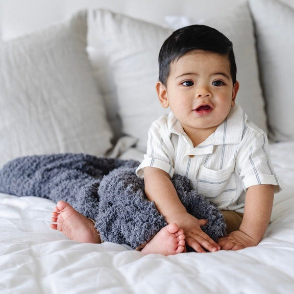 Adorable baby boy cuddled with his favorite Charcoal RIBBED BAMBONI® MINI BLANKETS - Saranoni