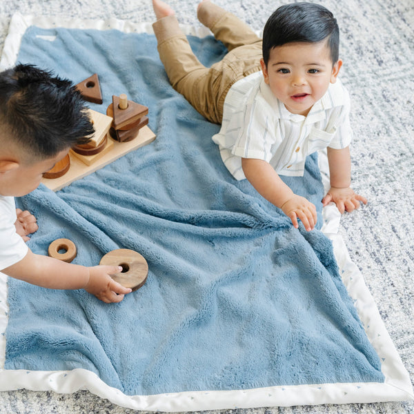 Luxuriously soft, blue-colored receiving blanket with a satin back, designed to offer a comforting embrace with a smooth, silky finish.