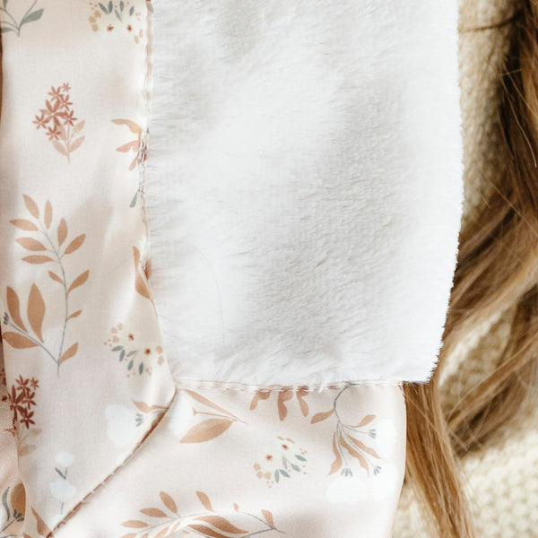 Cozy essence of a white and floral toddler blanket.