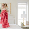 A little girl holds a Toddler Primrose (bold pink) Colored Lush Luxury Saranoni Blanket. The soft blanket is a baby blanket or toddler blanket.