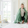 A little boy holds a Toddler Seagrass (dusty green) Colored Lush Luxury Saranoni Blanket. The soft blanket is a baby blanket or toddler blanket.