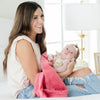 A mother holds her baby girl in a Luxury Receiving Primrose (bold pink) Colored Lush Saranoni Blanket. The soft blanket is a small blanket and a baby blanket or toddler blanket.