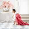 A little girl holds a Toddler Primrose (bold pink) Colored Lush Luxury Saranoni Blanket. The soft blanket is a baby blanket or toddler blanket.