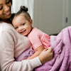 A mother holds her little girl in a Luxury Receiving Fairy Wings (light pink purple) Colored Lush Saranoni Blanket. The soft blanket is a small blanket and a baby blanket or toddler blanket.