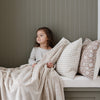 A little girl holds a Toddler Buttermilk (light tan) Colored Lush Luxury Saranoni Blanket. The soft blanket is a small blanket and a baby blanket or toddler blanket.