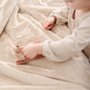 A little girl plays on Luxury Receiving Buttermilk (light tan) Colored Lush Saranoni Blanket. The soft blanket is a small blanket and a baby blanket or toddler blanket.