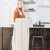 A woman holds a Luxury Extra Large Oversized Throw Buttermilk (light tan) Colored Lush Saranoni Blanket. The soft blanket is an extra large throw blanket and has a soft faux fur feeling.