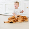 A little boy sits under a Luxury Receiving Camel (light yellowish brown) Colored Lush Saranoni Blanket. The soft blanket is a small blanket and a baby blanket or toddler blanket.