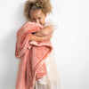 A little girl holds a Luxury Toddler Clay Colored Lush Saranoni Blanket. The soft blanket is a toddler blanket or baby blanket.