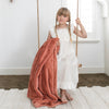 A little girl holds a Luxury Toddler Clay Colored Lush Saranoni Blanket. The soft blanket is a toddler blanket or baby blanket.