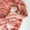 A baby lays in a Luxury Receiving Clay Colored Lush Saranoni Blanket. The soft blanket is a small blanket and a baby blanket or toddler blanket.