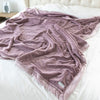 A Luxury Extra Large Oversized Throw Bloom (dusty purple) Colored Lush Saranoni Blanket. The soft blanket is an extra large throw blanket and has a soft faux fur feeling.