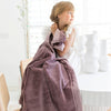 A little girl holds a Toddler Bloom (dusty purple) Colored Lush Luxury Saranoni Blanket. The soft blanket is small blanket and a baby blanket or toddler blanket.