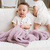 Two baby boys playing on couch with cute purple BAMBONI MINI BLANKETS - Saranoni