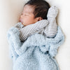 Close up of adorable baby boy snuggled in light blue BAMBONI® MINI BLANKETS - Saranoni