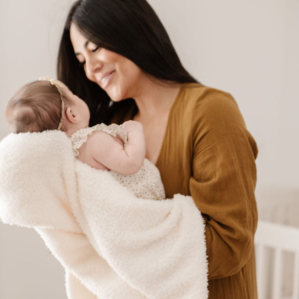 Mom soothing newborn baby girl in stretchy, white BAMBONI MINI BLANKETS - Saranoni