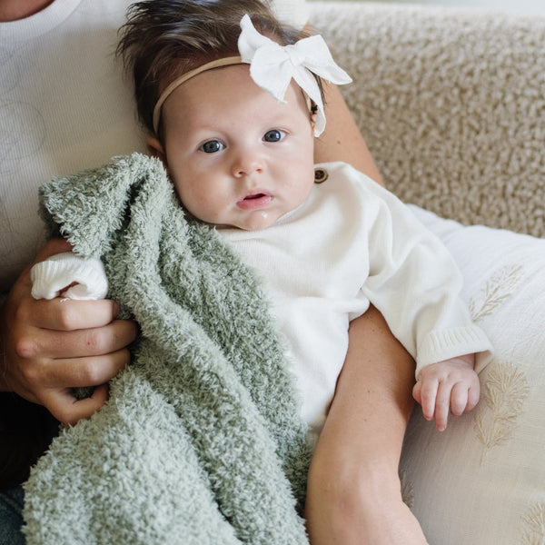 Baby girl loving her super soft and stretchy BAMBONI® MINI BLANKETS - Saranoni