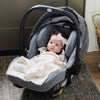 Cute baby girl sitting in carseat with beautiful BAMBONI® MINI BLANKETS - Saranoni