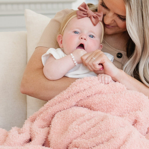 Mom and adorable baby girl snuggling with peachy pink BAMBONI® MINI BLANKETS - Saranoni