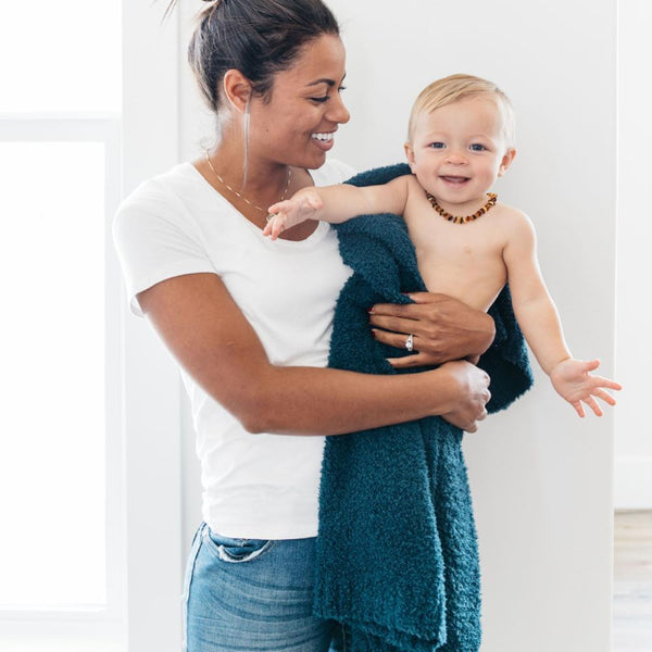 Little boy happily smiling with mom, snuggled in Nautical Blue BAMBONI RECEIVING BLANKETS - Saranoni