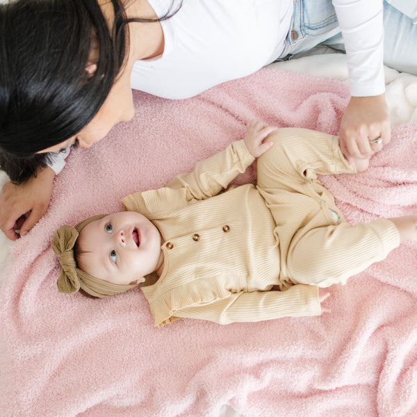 Mom and adorable baby playing on light pink BAMBONI RECEIVING BLANKETS - Saranoni