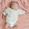 Adorable baby girl falling asleep on Peach BAMBONI® RECEIVING BLANKETS - Saranoni