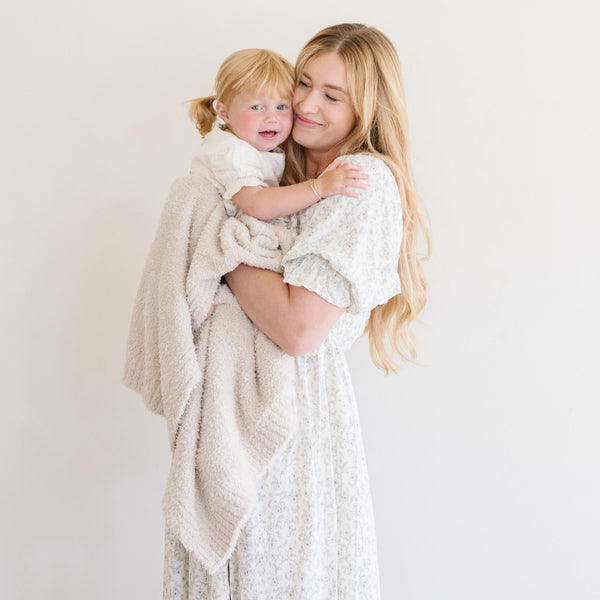 Mom snuggling into toddler with Buttermilk BAMBONI® RECEIVING BLANKETS - Saranoni