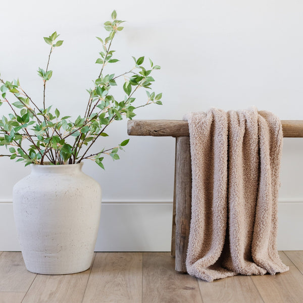 Stunning home decor with plant, wooden bench, and Birch BAMBONI® RECEIVING BLANKETS - Saranoni