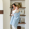 Mom swinging baby wrapped in light blue BAMBONI® RECEIVING BLANKETS - Saranoni