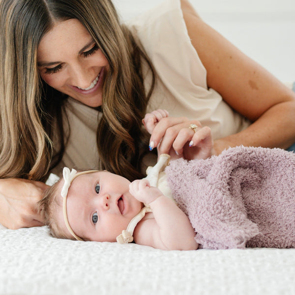 Mom and baby girl laying with soft and comfy light purple Birchwood BAMBONI RECEIVING BLANKETS - Saranoni