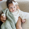 Adorable baby girl cuddling with mom in sage green BAMBONI® RECEIVING BLANKETS - Saranoni