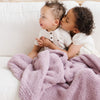 Brother and sister playing on couch with beautiful Birchwood BAMBONI RECEIVING BLANKETS - Saranoni