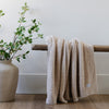 Stunning home decor with greenery, wooden bench, and Buttermilk, neutral colored BAMBONI® RECEIVING BLANKETS - Saranoni