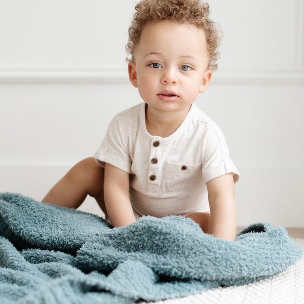 Baby boy playing on floor with stretchy soft Spruce BAMBONI RECEIVING BLANKETS - Saranoni