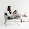 Girl sitting in chair reading magazine, snuggled in Gray BAMBONI THROW BLANKETS - Saranoni