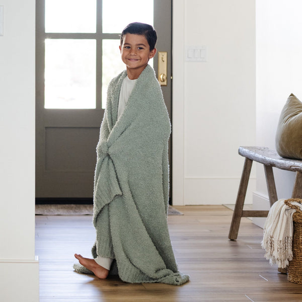 Young boy walking around beautiful home, wrapped in Sage BAMBONI® TODDLER BLANKETS - Saranoni